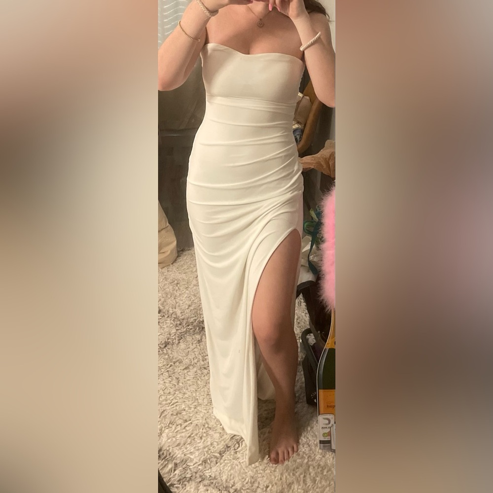 Sleeveless white formal dress. Open back with slit.
